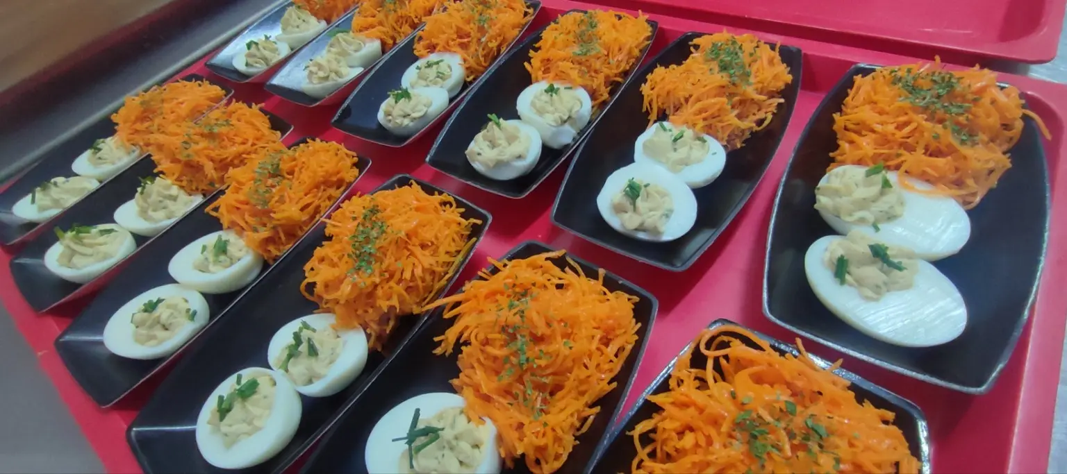 Assiettes d'œufs et de carottes râpées préparées par le traiteur