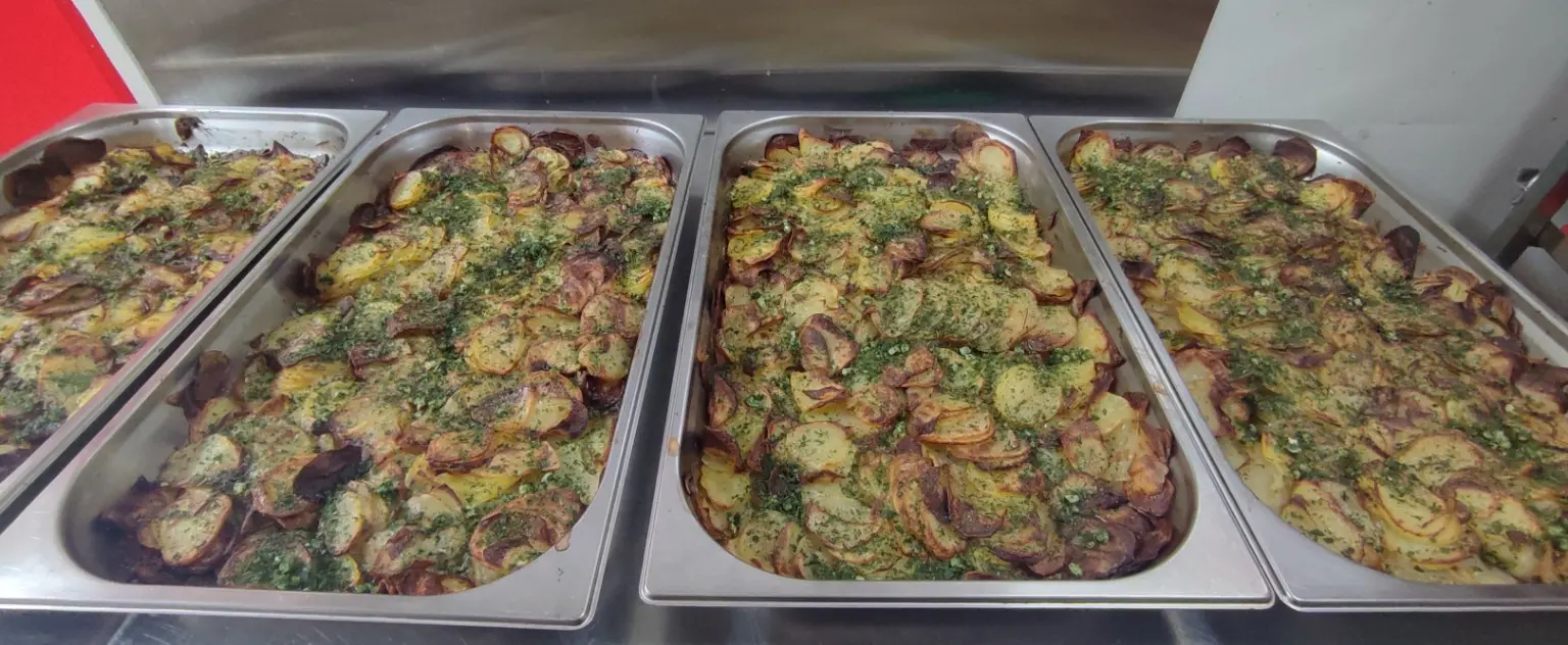 Grands plats de pommes de terre rôties aux herbes pour un repas de groupe